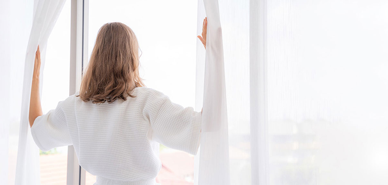 Frau schaut aus dem Fenster